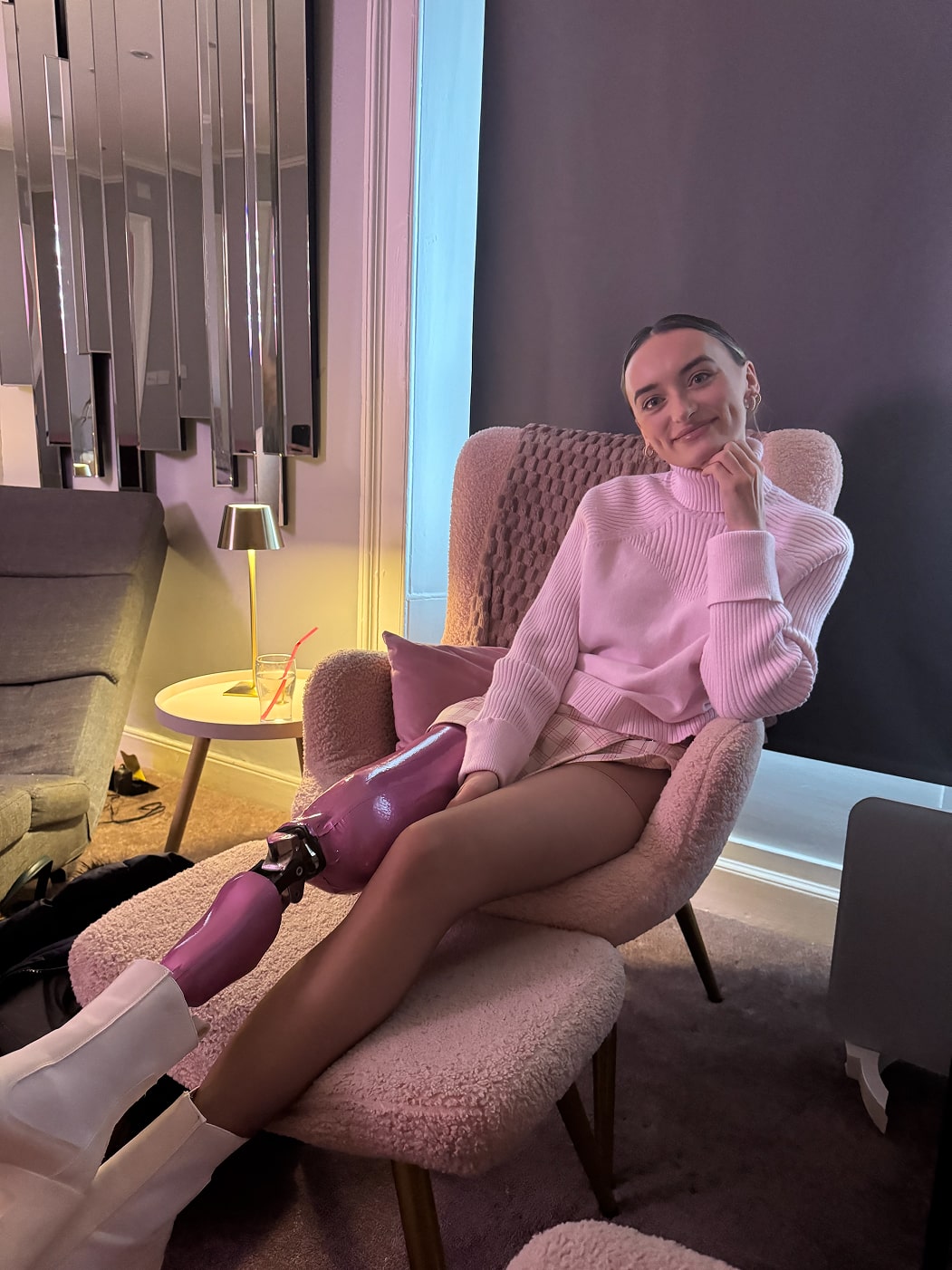 Woman wears metallic pink lower limb prosthetic